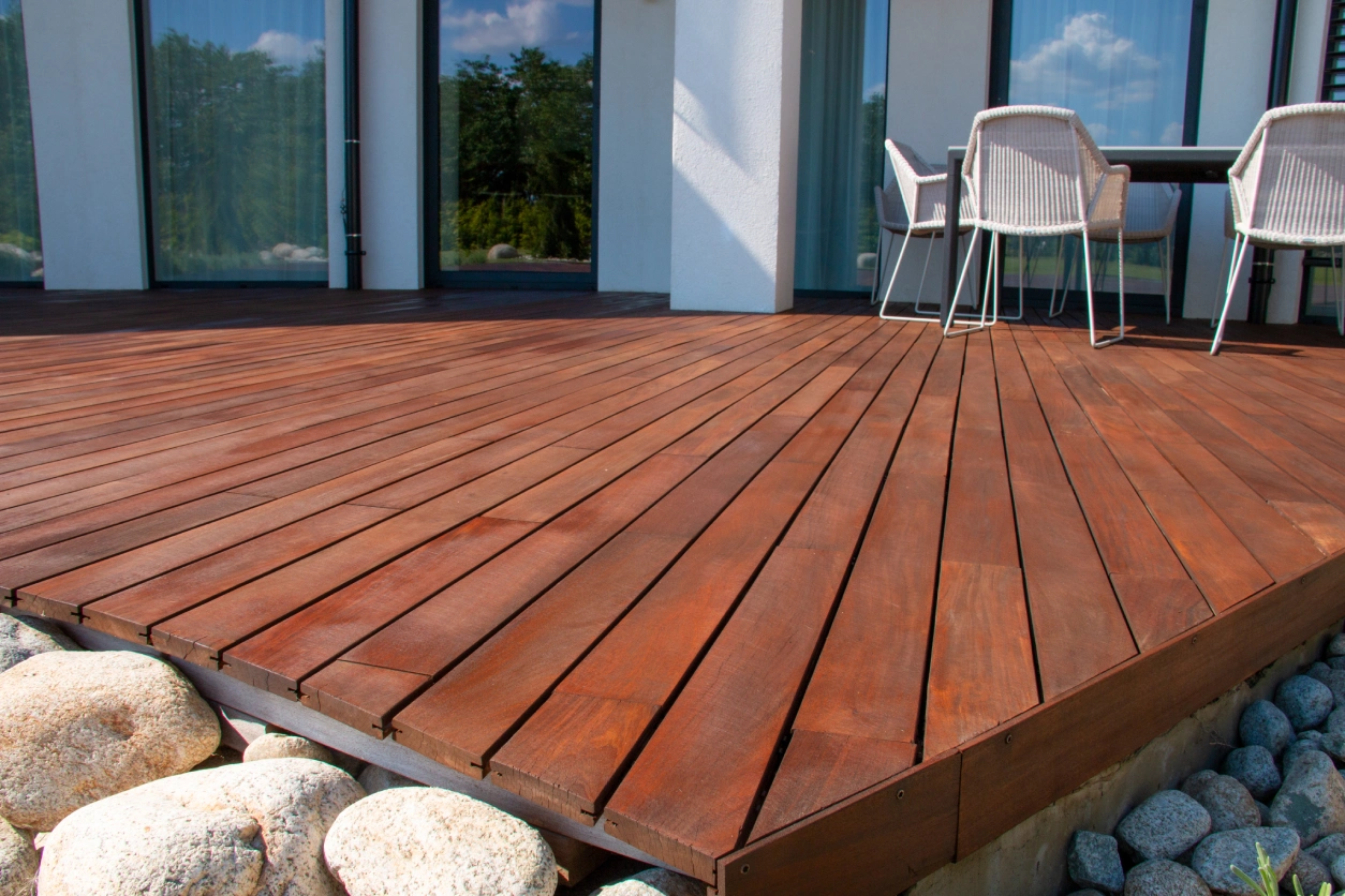 Rich brown wood deck with patio furniture.